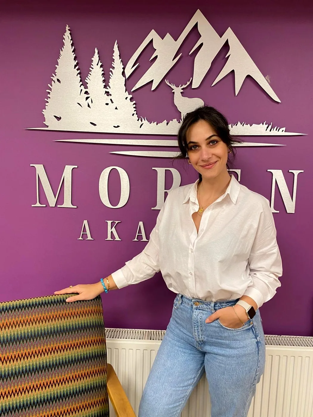 Moren Akademi co-founder Cemre Işık in front of the academy's logo wall